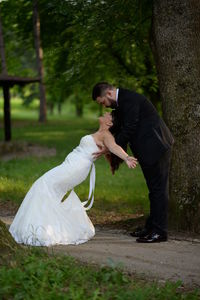 Rear view of man and woman standing by tree