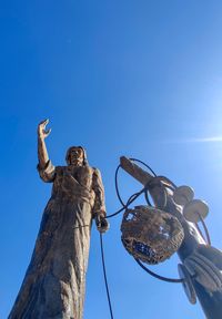 Low angle view of statue against clear blue sky