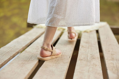 Low section of woman standing on wooden floor