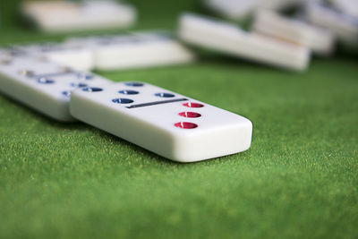 Close-up of dominoes on green table