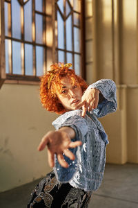 Young alternative redhead girl dancing in a blue blouse