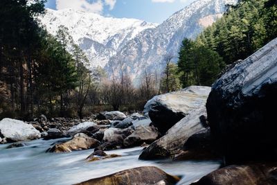 Scenic view of river by snowcapped mountains