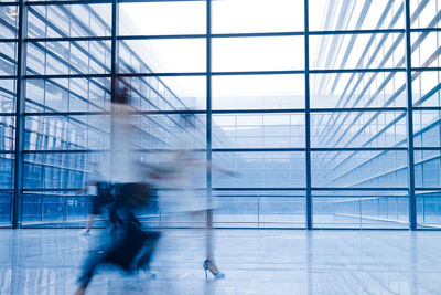 Blurred motion of people walking in modern building