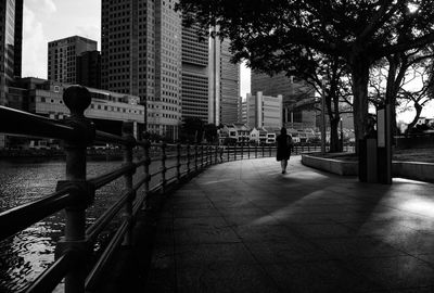 Rear view of man walking on footpath in city