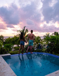 Rear view of woman standing against swimming pool