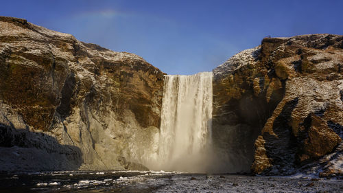 Scenic view of waterfall against sky