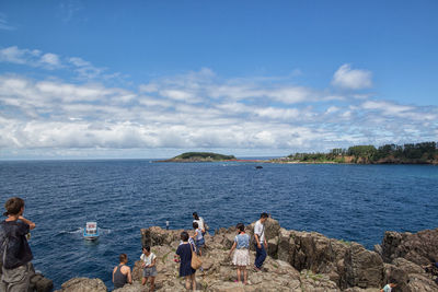 People on beach against blue sky