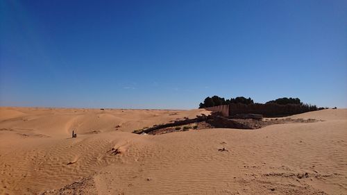 Scenic view of desert against clear blue sky