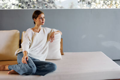 Young woman using mobile phone while sitting on table