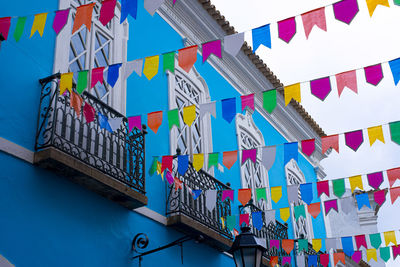 Low angle view of multi colored flags and facade of a house