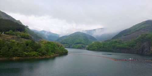 Scenic view of river amidst mountains against sky