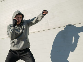 Low angle view of man standing against wall