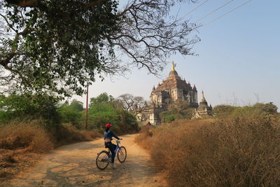 Man cycling on bicycle against clear sky