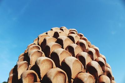 Low angle view of stack against blue sky