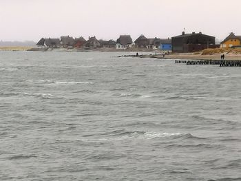 Scenic view of sea against buildings in city