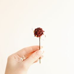 Close-up of hand holding red rose