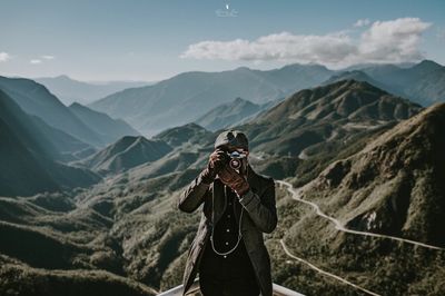 Man photographing on mountain range