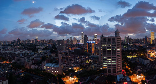 High angle view of illuminated buildings against sky at dusk