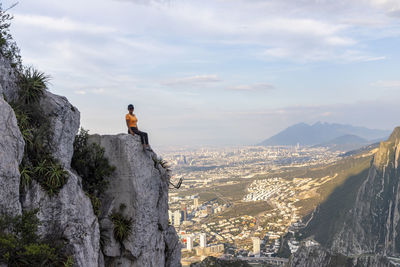 Panoramic view of people looking at cityscape against sky