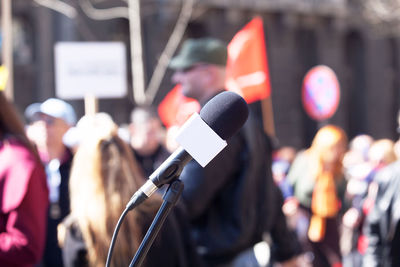 Close-up of microphone with people in background