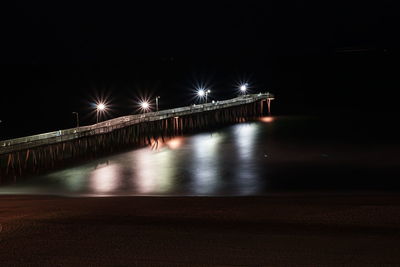 Illuminated bridge over street at night