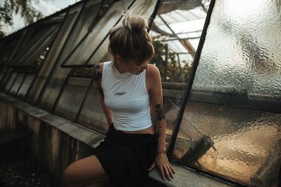 Rear view of woman sitting against wall