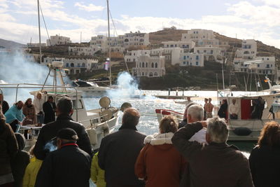 People on fountain by sea against sky