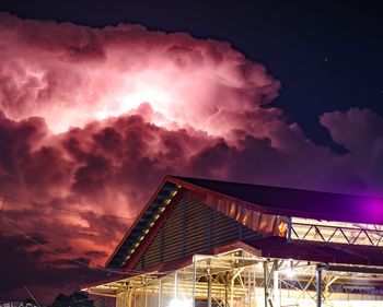 Low angle view of illuminated building against sky at sunset