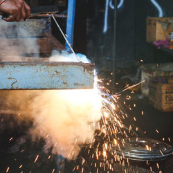 Cropped hand welding metal in workshop