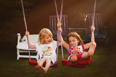 Siblings swinging at playground