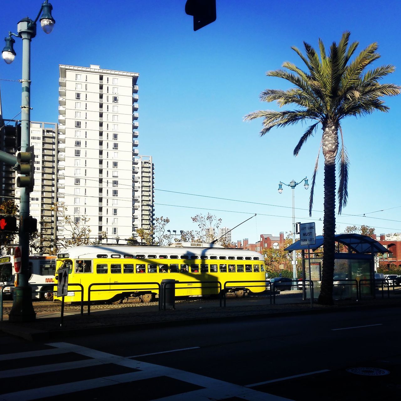 YELLOW BUS ON CITY AGAINST SKY