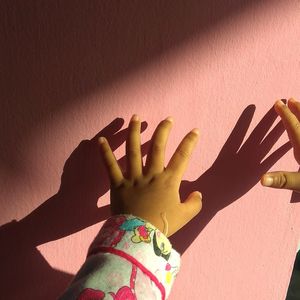 Cropped hands of child against wall