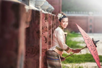 Portrait of smiling young woman standing outdoors