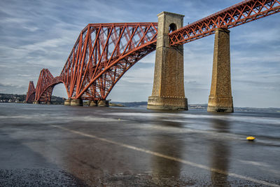 View of bridge over sea against cloudy sky