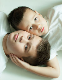 Portrait of cute baby boy lying on bed at home