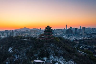 Buildings in city at sunset