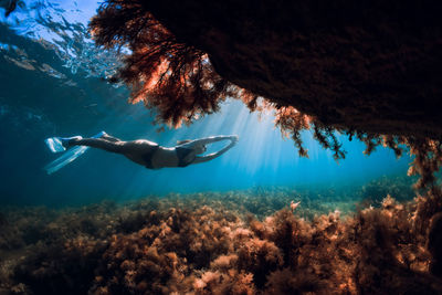 Low section of woman swimming in sea