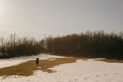 Man standing on field against sky during winter