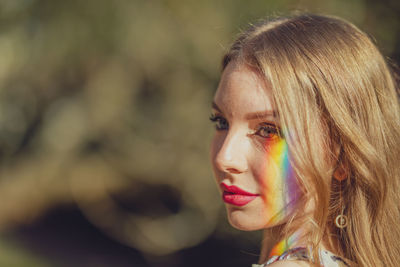 Close-up of young woman with spectrum on face