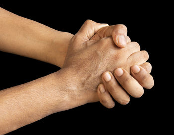 Close-up of hands over black background