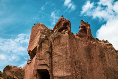 Low angle view of rock formations against sky