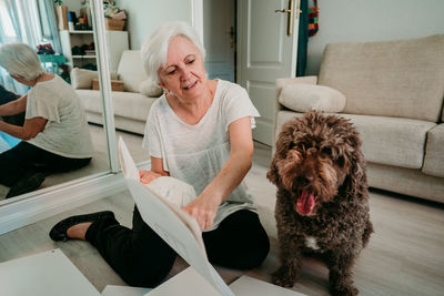 Woman with dog working on wood at home