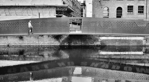 Reflection of woman walking on water in city