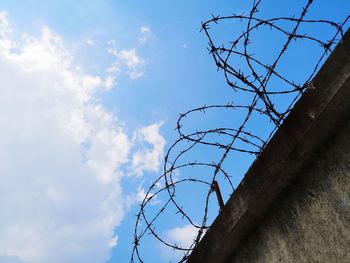 Low angle view of barbed wire against sky