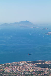 High angle view of sea by city against sky