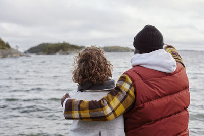 Couple embracing and looking at sea