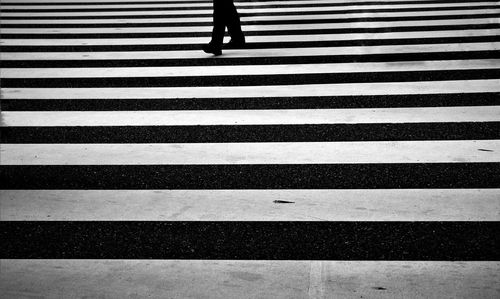 Low section of man walking on zebra crossing