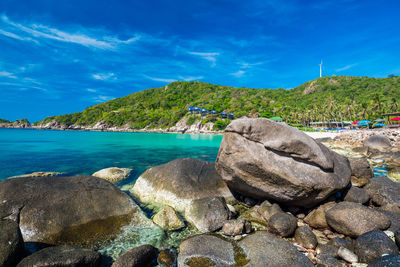 Rocks on beach against blue sky