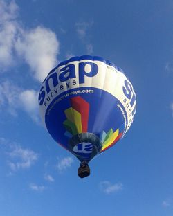 Low angle view of colorful balloons against blue sky