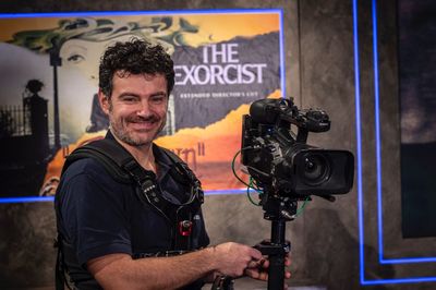 Portrait of smiling photographer holding tripod